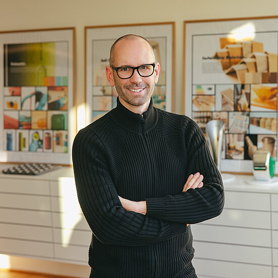 Vorwerk: Foto: Das Foto zeigt Jan Delfs, den Chefdesigner von Vorwerk. Er steht da, mit lässig vor dem Bauch verschränkten Armen und lächelt direkt in die Kamera.