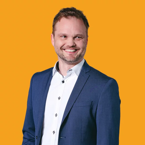 Vorwerk: Foto: Ein Mann in weißem Hemd und blauem Jackett lächelt in die Kamera. Er ist der Ingenieur, um den es in der Story geht.