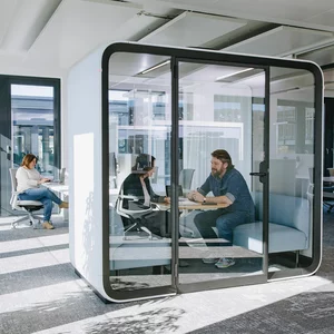 Vorwerk: Foto: Zwei Personen sitzen in einer schalldichten Meeting-Box, die man auch Think Tank, zu deutsch: Denkfabrik nennt, und tauschen sich zu einem Thema aus.